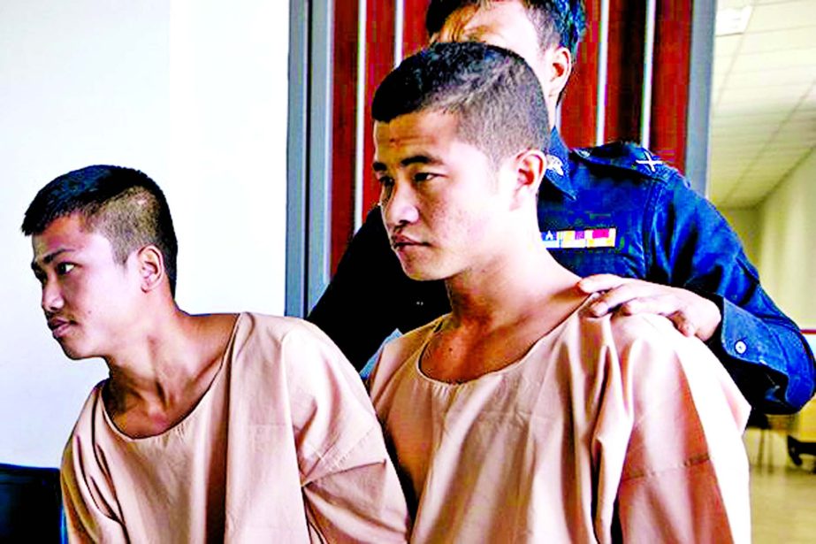 Myanmar migrants Win Zaw Htun, right, and Zaw Lin, left, both 22, are escorted by officials after their guilty ruling at court in Koh Samui Dec 24. The court on Thursday sentenced the two Myanmar migrants to death for killing British backpackers David Mil