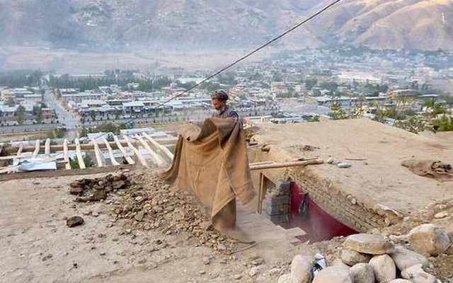 A man clears rubble from the roof of his house after an earthquake in Fayzabad, capital of Badakhshan province, Afghanistan October 26, 2015. Reuters