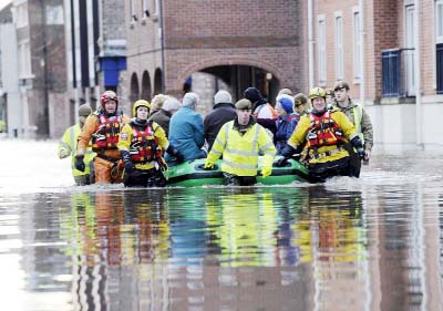 Members of the army and rescue teams help evacuate people from flooded properties after they became trapped by rising floodwater when the River Ouse bursts its banks in York city center on Sunday.