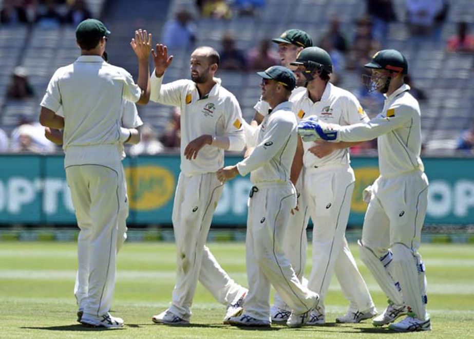 Australia's Nathan Lyon, (second from left) celebrates with teammates after capturing the wicket West Indies' Carlos Brathwaite during their cricket test match in Melbourne, Australia on Monday.