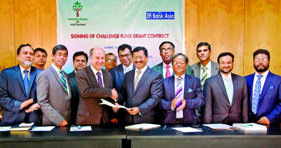 Md Mehmood Husain, Managing Director of Bank Asia and Chris August, Team Leader of Business Finance for the Poor in Bangladesh (BFP-B) exchanging documents of an agreement on implementing the Challenge Fund titled "Business Finance for the Poor in Bangla