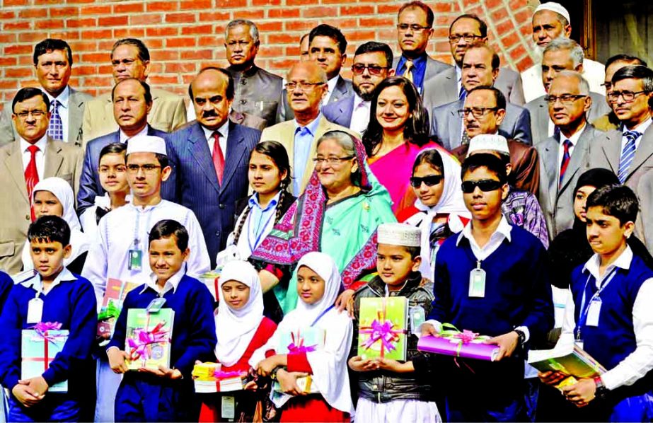 Prime Minister Sheikh Hasina poses for photograph with the students after inaugurating the book festival and receiving the results of PSC, Ebtedayee, JSC and JDC examinations at her official residence Ganobhaban on Thursday. BSS photo