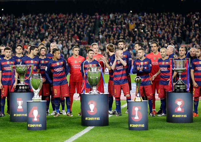 FC Barcelona players pose with the five trophies the team won in 2015 before their last match of the year a Spanish La Liga soccer match against Betis, at the Camp Nou stadium in Barcelona, Spain on Wednesday.