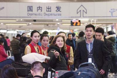 Ursula Gauthier (L), the Beijing-based correspondent for French news magazine L'Obs, speakes with hostesses at the airport before she takes her flight back to France, in Beijing on Thursday.