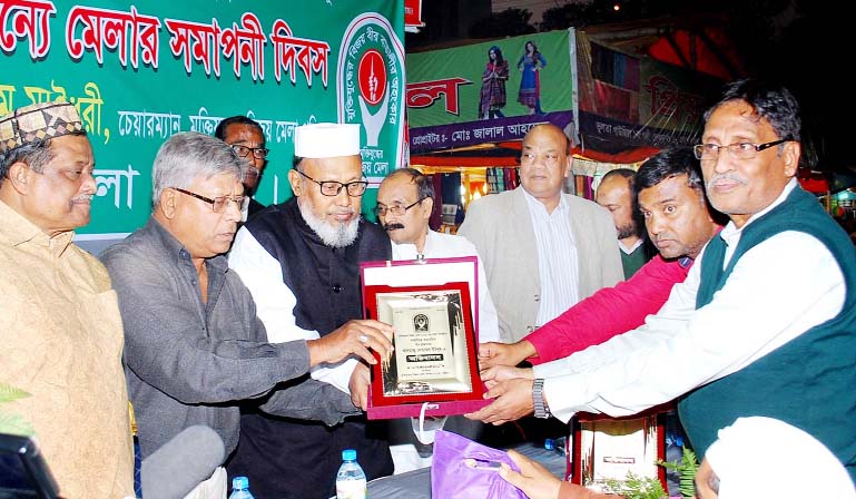 Chittagong City Awami League President ABM Mohiuddin Chowdhury distributing crest among the best stall owners at the concluding ceremony of Liberation War Fair yesterday.