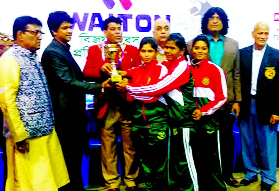 Bangladesh Army, the winners of the Women's Division of the Walton Victory Day Wrestling Competition receiving the champions trophy from chief guest FM Iqbal Bin Anwar Dawn, First Senior Additional Director of Walton at the Gymnasium of National Sports C