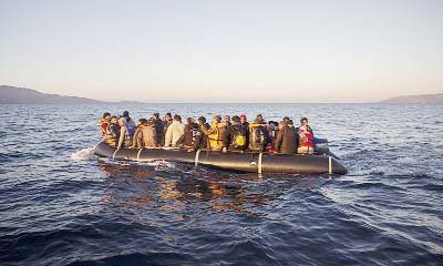 Refugees and migrants onboard a dinghy approach the Greek island of Lesbos on their way from a Turkish coast.