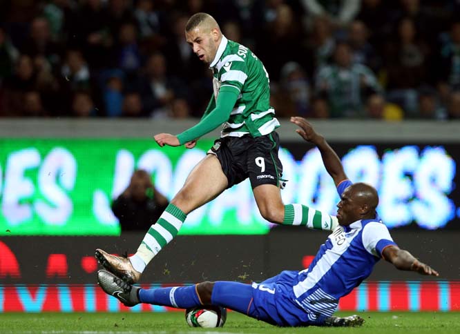 Sportingâ€™s Islam Slimani, left, jumps over Portoâ€™s Bruno Martins Indi during a Portuguese league soccer match at the Alvalade stadium in Lisbon on Saturday.