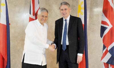 Philippine Foreign Secretary Albert del Rosario (L) shakes hands with his British counterpart Philip Hammond during a visit to the Philippine foreign ministry headquarters in Manila on Thursday.