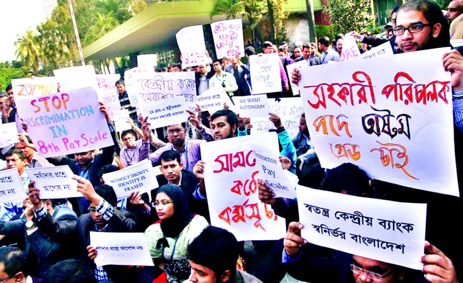 Officers and employees of Bangladesh Bank formed a human chain protesting for degrading them in 8th National Pay Scale in front of the Bank on Thursday.