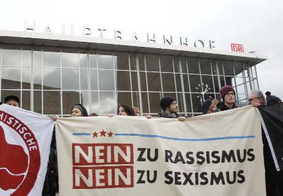 People protest in front of the main station in Cologne, Germany, on Wednesday. The poster reads: "No to Racism, No to Sexism".