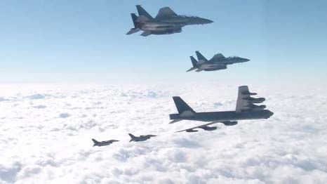 The US B-52 Stratofortress (C) was escorted by a South Korean F-15K fighter jet (L) and a US F-16 fighter jet (R) as it flew over the air base in Pyeongtaek, south of Seoul, on Sunday.