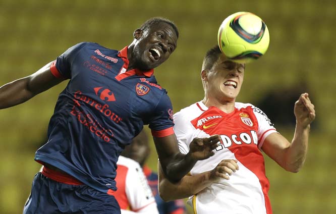 Monaco's Guido Carrillo (right) jumps for the ball with Ajaccio's Kader Mangane during their French League One soccer match in Monaco stadium on Saturday.