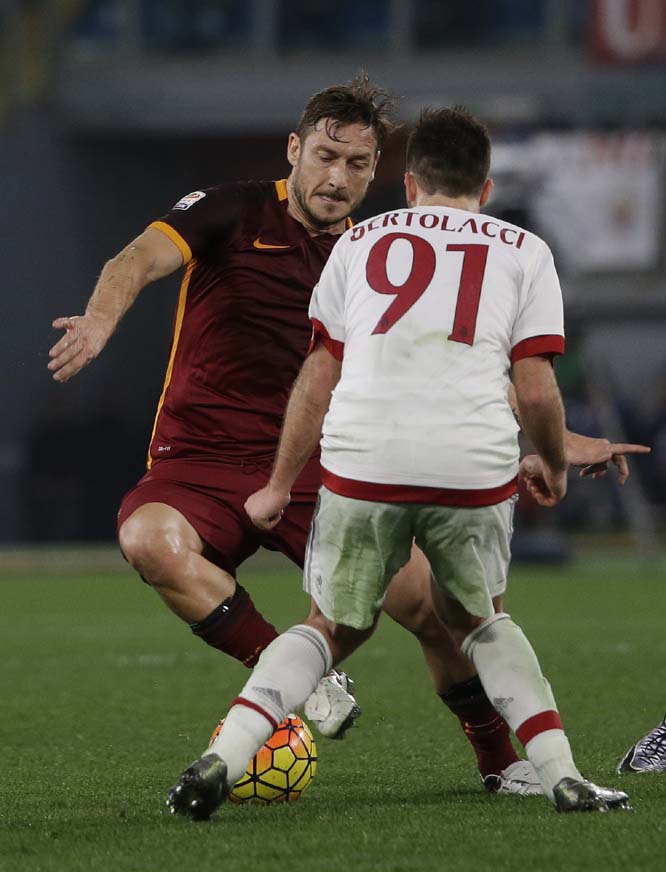 Roma's Francesco Totti (left) controls the ball past AC Milan's Andrea Bertolacci during an Italian Serie A soccer match between Roma and AC Milan at Rome's Olympic stadium on Saturday.