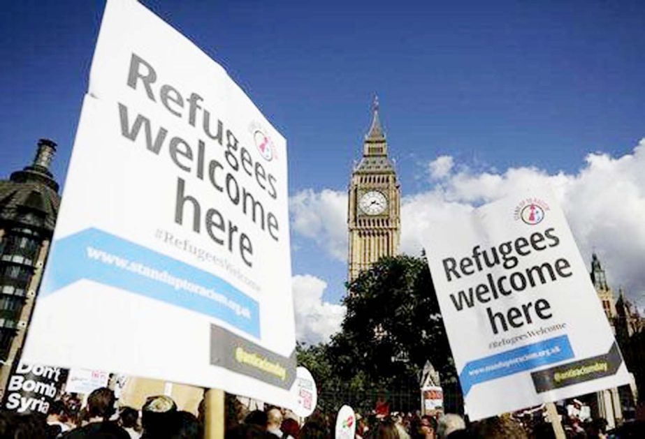 Protesters hold up placards during a demonstration to express solidarity with migrants and to demand the government welcome refugees into Britain, in London.