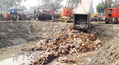 Rotten imported fruit consignments are being dumped into large hole at Patenga area in the city yesterday.