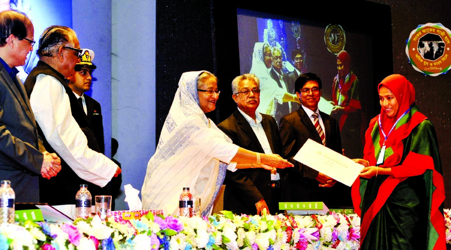 Prime Minister Sheikh Hasina handing over a cheque of loan to an entrepreneur while inaugurating loan distribution at five percent interest to make Bangladesh self-reliant in milk production at Krishibid Institution, Bangladesh auditorium in the city's F