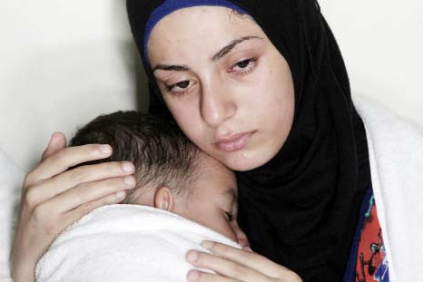 A refugee holds her baby after being rescued from a sinking dinghy off the Greek island of Lesbos.