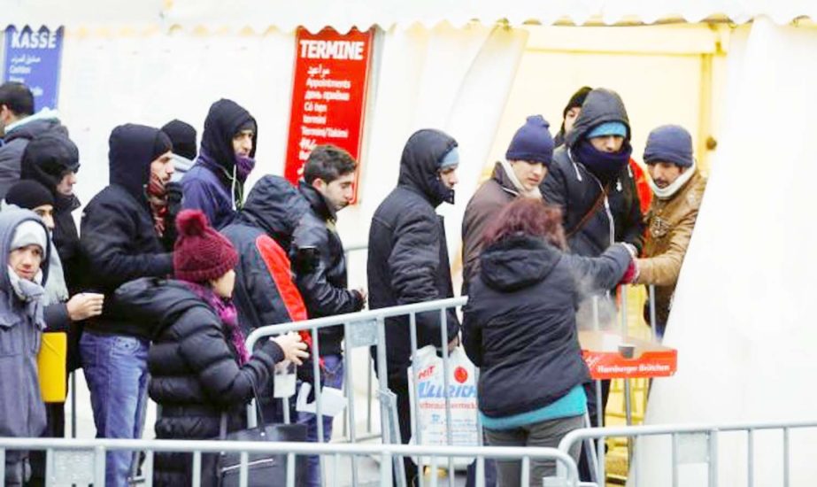 Migrants queue to enter a tent that serves as a waiting room at the Berlin Office of Health and Social Affairs (LAGESO), in Berlin, Germany.
