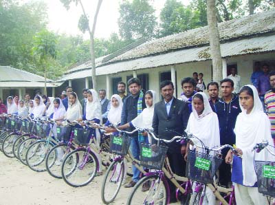JHENAIDAH: Girls students of Bhaina Shahid Mosharraf-Daliluddin High School posed with teachers and education department officials with their new bicycles at the school premises recently. .
