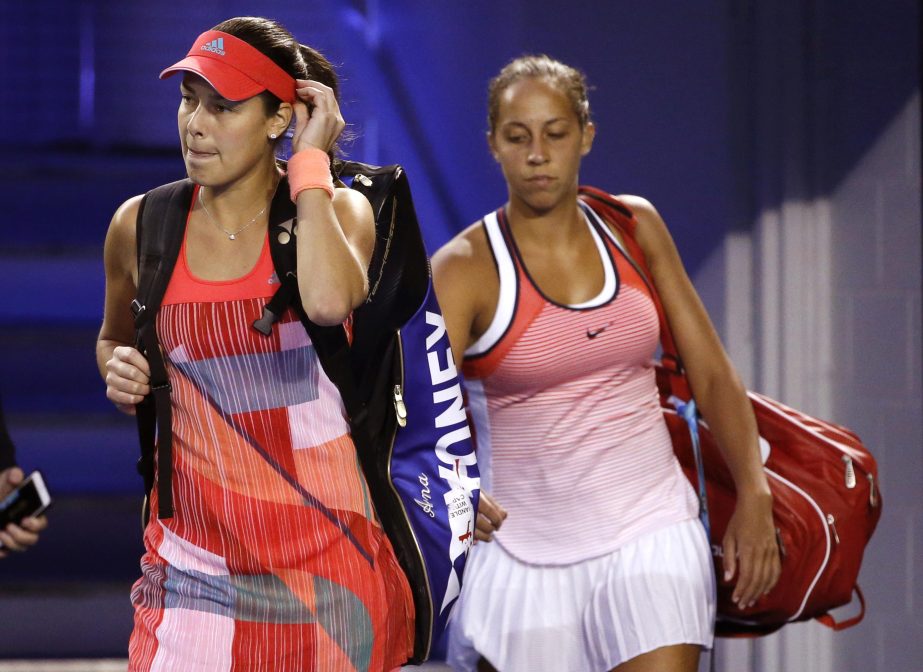 Ana Ivanovic (left) of Serbia and Madison Keys of the United States walk back onto Rod Laver Arena after play was suspended for just under an hour due to a medical emergency in the crowd during their third round match at the Australian Open tennis champi