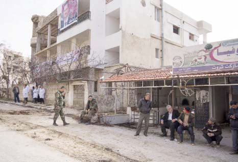 People stand on a street in Salma, Syria on Friday. Syrian government forces relying on Russian air cover have recently seized Salma, located in Syria's province of Lattakia, from militants.