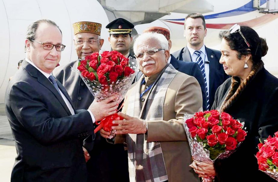 French President Francois Hollande, left, receives flowers from India's Haryana state Chief Minister Manohar Lal Khattar, second right, as Haryana state Governor Kaptan Singh Solanki, second left, and Indian lawmaker Kirron Kher, right, join in receiving