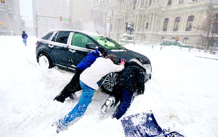 Good Samaritans help a stuck motorist in front of City Hall in Philadelphia as snow falls over the region. Internet photo