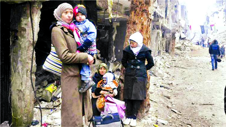 Residents wait to receive food aid distributed by the U.N. Relief and Works Agency (UNRWA) at the besieged al-Yarmouk camp.