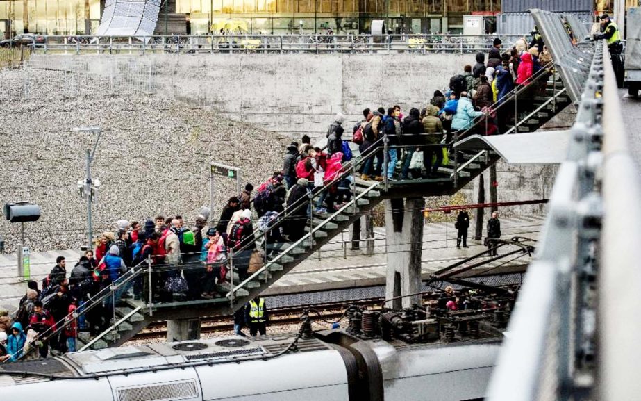 Swedish police organise refugees as they arrive at the Hyllie train station on the outskirts of Malmo.