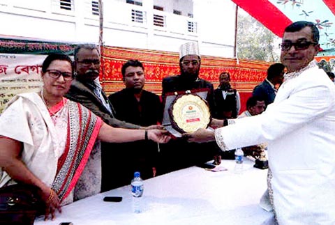 Teacher of Singair Model Pilot High School Md Altaf Hossain (right) receiving the crest of honour at the School Ground in Singair Upazila under Manikganj District recently. The prize-giving ceremony of the 45th National School & Madrasa Winter Sports Comp