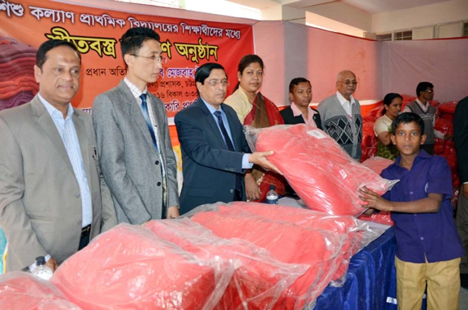 Deputy Commissioner of Chittagong Mesba Uddin distributing winter clothes among the students of Child Welfare Primary School as chief guest on Thursday . ADC (Edn & ICT) Debmoy Dewan presided over the function.