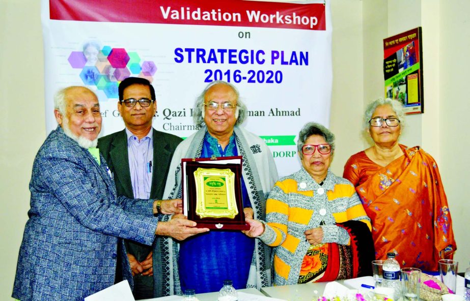 Dr Qazi Kholiquzzaman Ahmad, Chairman of Palli Karma-Sahayak Foundation, receiving the crest of 'Somriddhi Bondhu' title for his contribution to the rural development in Bangladesh from AHM Nouman, Founder of DORP at a workshop at its office on Friday.