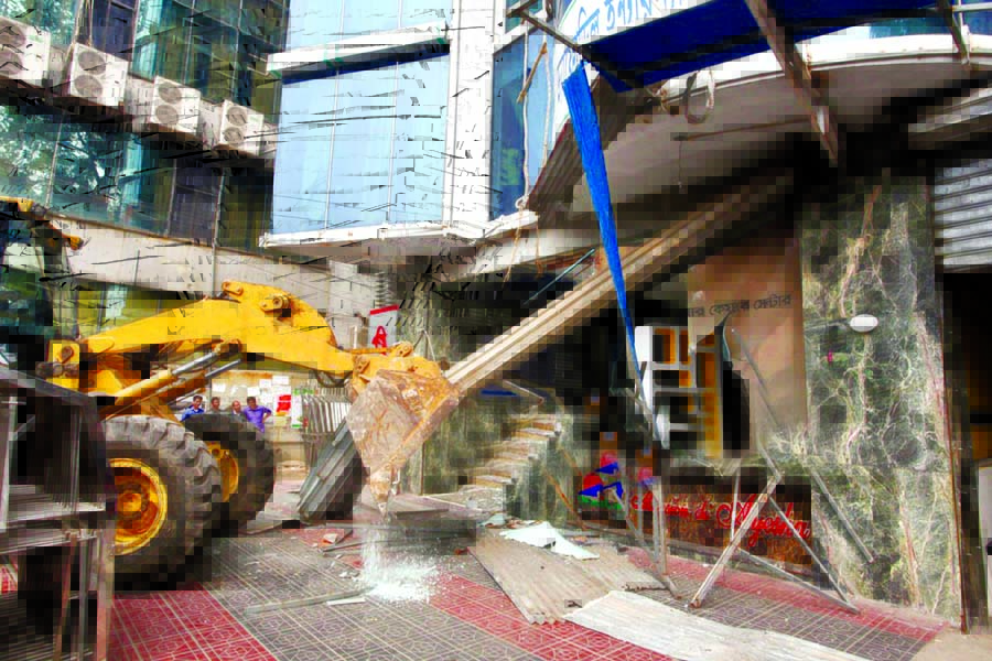 RAJUK authority demolishing illegally extended structures by various establishments at Dhanmondi area on Wednesday.