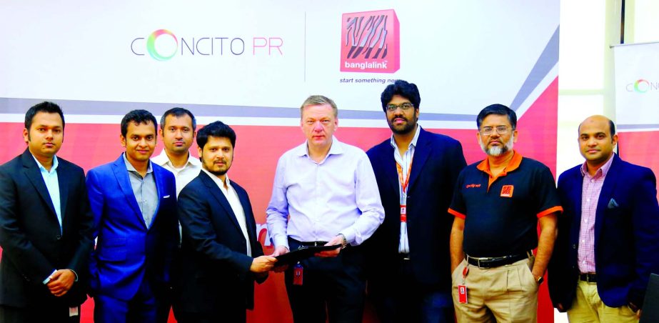 Managing Director of Banglalink Erik Aas exchanging documents with Managing Director of Concito PR Moeen Tariq at the Head Office of Banglalink in the city on Thursday.