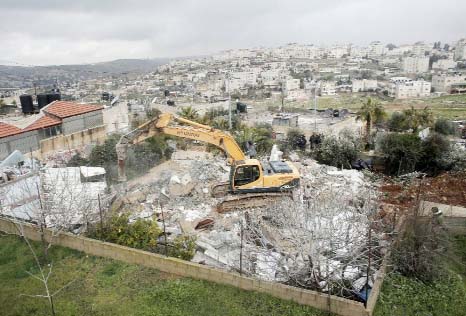 Israeli authorities use heavy machinery to demolish a house belonging to a Palestinian family in the Arab east Jerusalem neighbourhood of Shuafat.