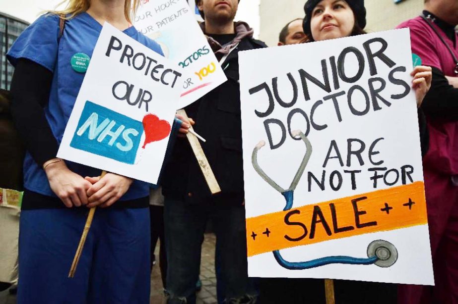 Junior doctors hold up placards on a picket line during a 24-hour strike over pay and conditions outside St Thomas' Hospital in London on Wednesday.