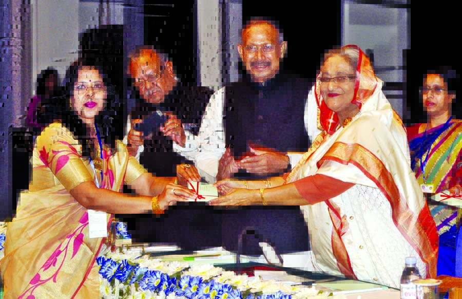 Prime Minister Sheikh Hasina handing over cheque of donation to a researcher of post-graduate studies and research under Bangabandhu Fellowship and National Science and Technology Project at Osmani Memorial Hall in the city on Wednesday. BSS photo