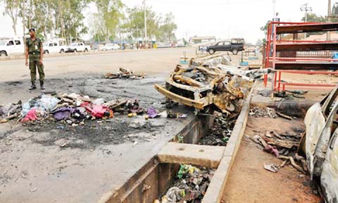 Nigerian soldier guarding at the scene of an explosion.