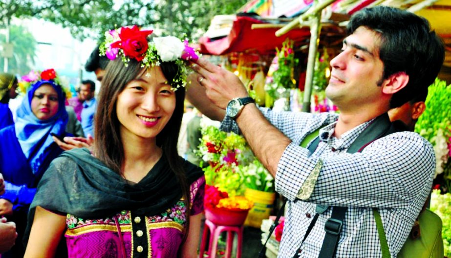 A foreigner is being decorated with flowers by a Bangali friend marking the occasion of World Valentine's Day yesterday.