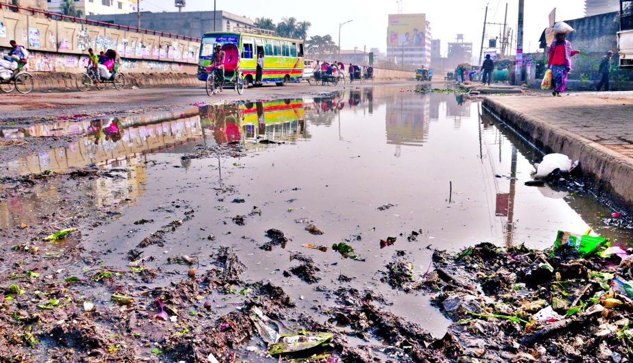 A portion of the main thoroughfare in city's Jatrabari area is in dilapidated condition as dirty water from sewerage line and dumped garbage spiled up causing sufferings to commuters. This photo was taken on Monday.