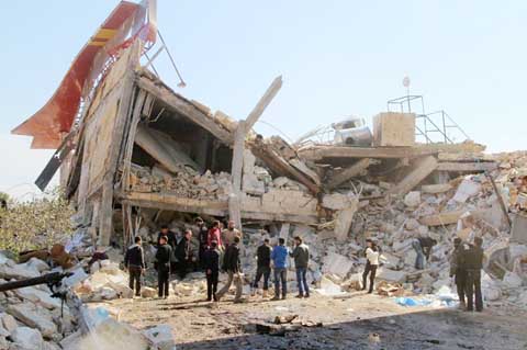 People gather around the rubble of a hospital supported by Doctors Without Borders (MSF) near Maaret al-Numan, in Syria's northern province of Idlib on Monday after the building was hit by suspected Russian air strikes.