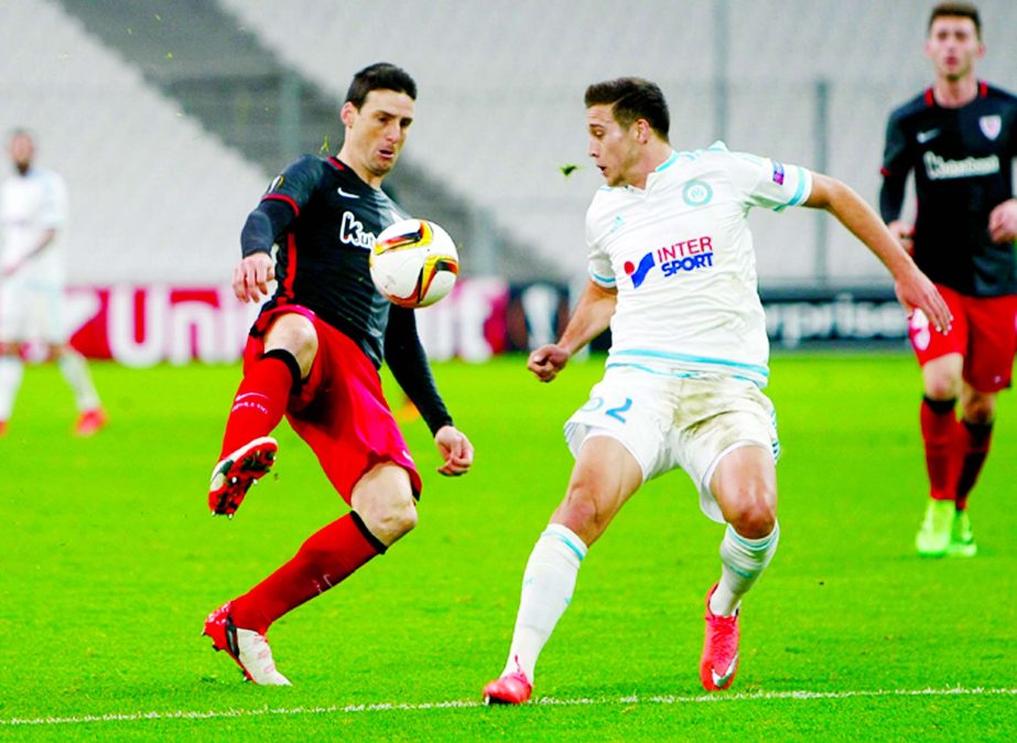 Bilbao's forward Aritz Aduriz Zubeldia (left) challenges for the ball with Marseille's defender Javier Manquillo during a Europa League Round of 32 first leg soccer match between Marseille and Bilbao at the Velodrome stadium in Marseille, southern Franc