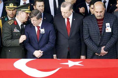 Prime Minister Ahmet Davutoglu (2nd L) chats with Chief of Staff General Hulusi Akar (L) as President Tayyip Erdogan (2nd R) looks on during a funeral ceremony for Army officer Seckin Cil in Ankara, Turkey on Friday.