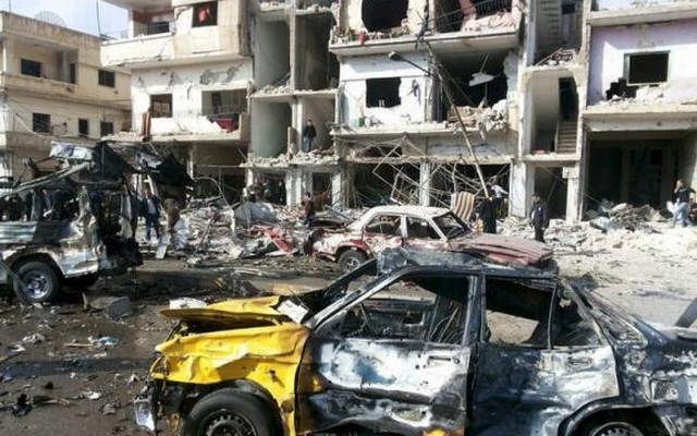 People inspect the site of a two bomb blasts in the government-controlled city of Homs, Syria, in this handout picture provided by SANA on February 21, 2016. ReutersSANAHandout via Reuters
