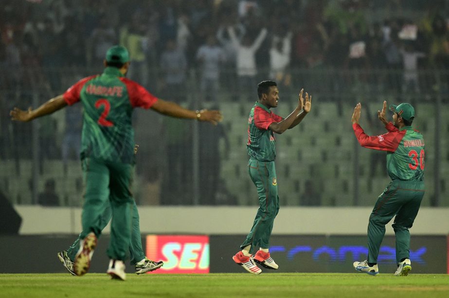 Bangladesh cricketer Al-Amin Hossain (C) celebrates with teammates after the dismissal of unseen Indian batsman Shikhar Dhawan during a Twenty20 match between India and Bangladesh for The Asia Cup T20 cricket tournament at The Sher-e-Bangla National Crick