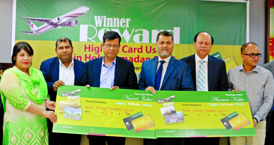 Md Nazmus Salehin, Managing Director of Standard Bank Limited, handing over air tickets to Nusrat Jabin and Anowar Kabir for highest transaction doers of SBL Credit Card under "Ramadan Transaction Campaign 2015" at the bank's head office recently. Addi