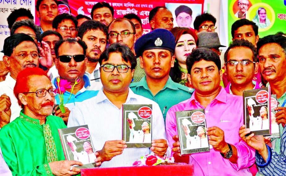 Dhaka South City Corporation Mayor Mohammad Sayeed Khokon along with others holds the copies of a book titled 'Amar Chhatra Rajneeti and Jatir Janak Kanya Sheikh Hasina' written by Hasibur Rahman Manik at its cover unwrapping ceremony at Nazrul Mancha o
