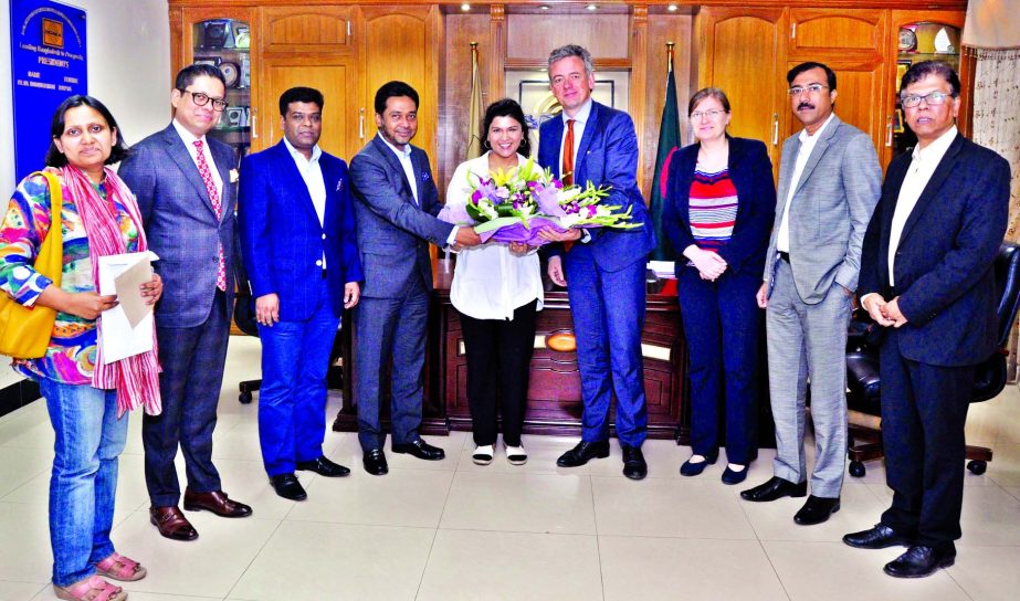 Mohammad Nasir, receiving a flower bouquet from Anosha Wahidi, Economic Cooperation and Development Department and Hans Christian Winkler, Head of Taskforce Economy and Human Rights of German at BGMEA office recently.