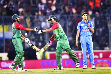 Soumya Sarkar (L) celebrates with his teammate Tamim Iqbal (C) after hitting a boundery as the Indian cricketer Ashish Nehra (R) looks on during the Asia Cup T20 cricket tournament final match between Bangladesh and India at the Sher-e-Bangla National Cri